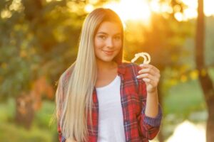 Woman holding clear aligner, representing Invisalign treatment in Horizon City, TX