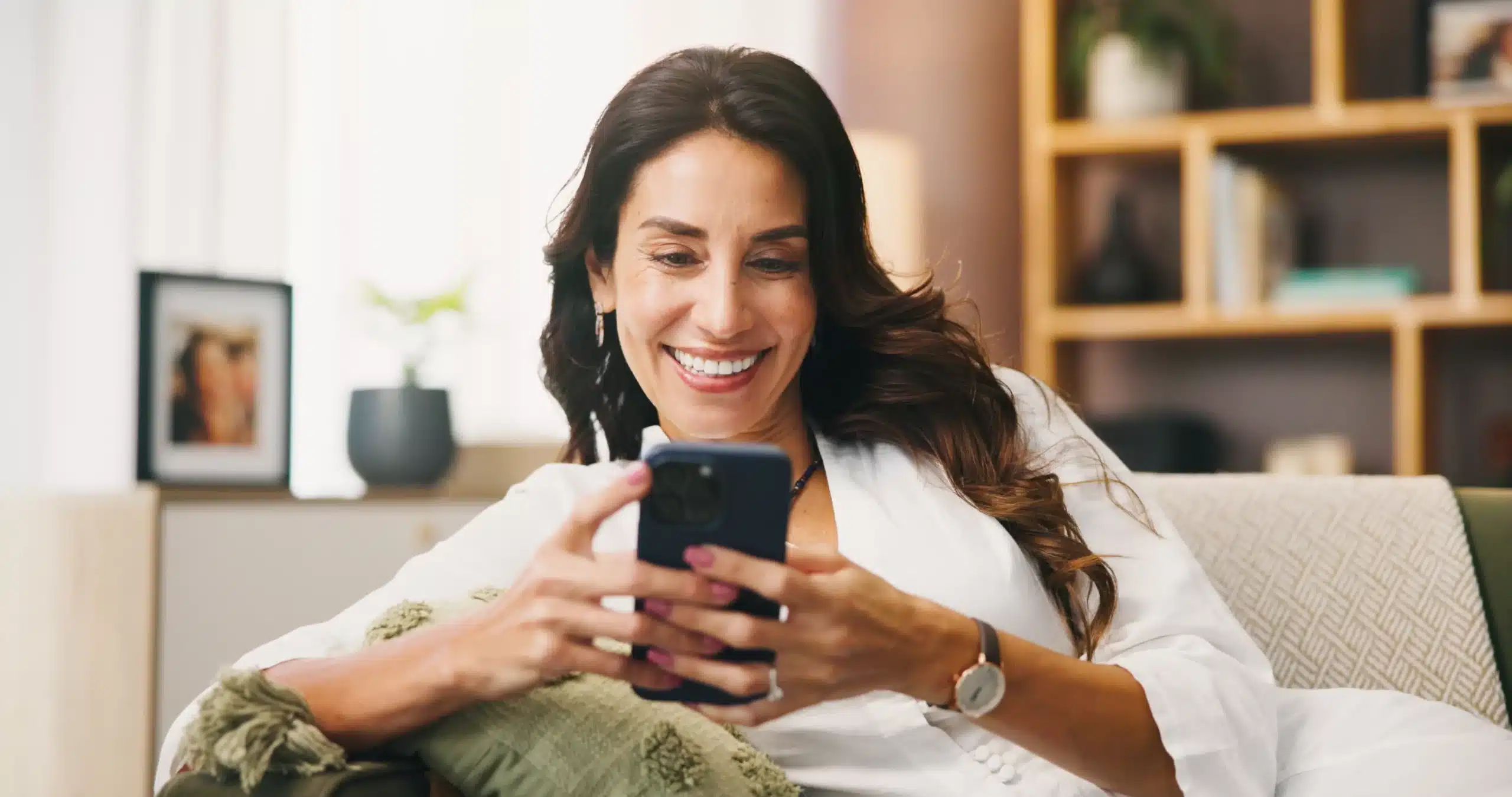 Smiling woman using phone, representing easy dental appointment scheduling