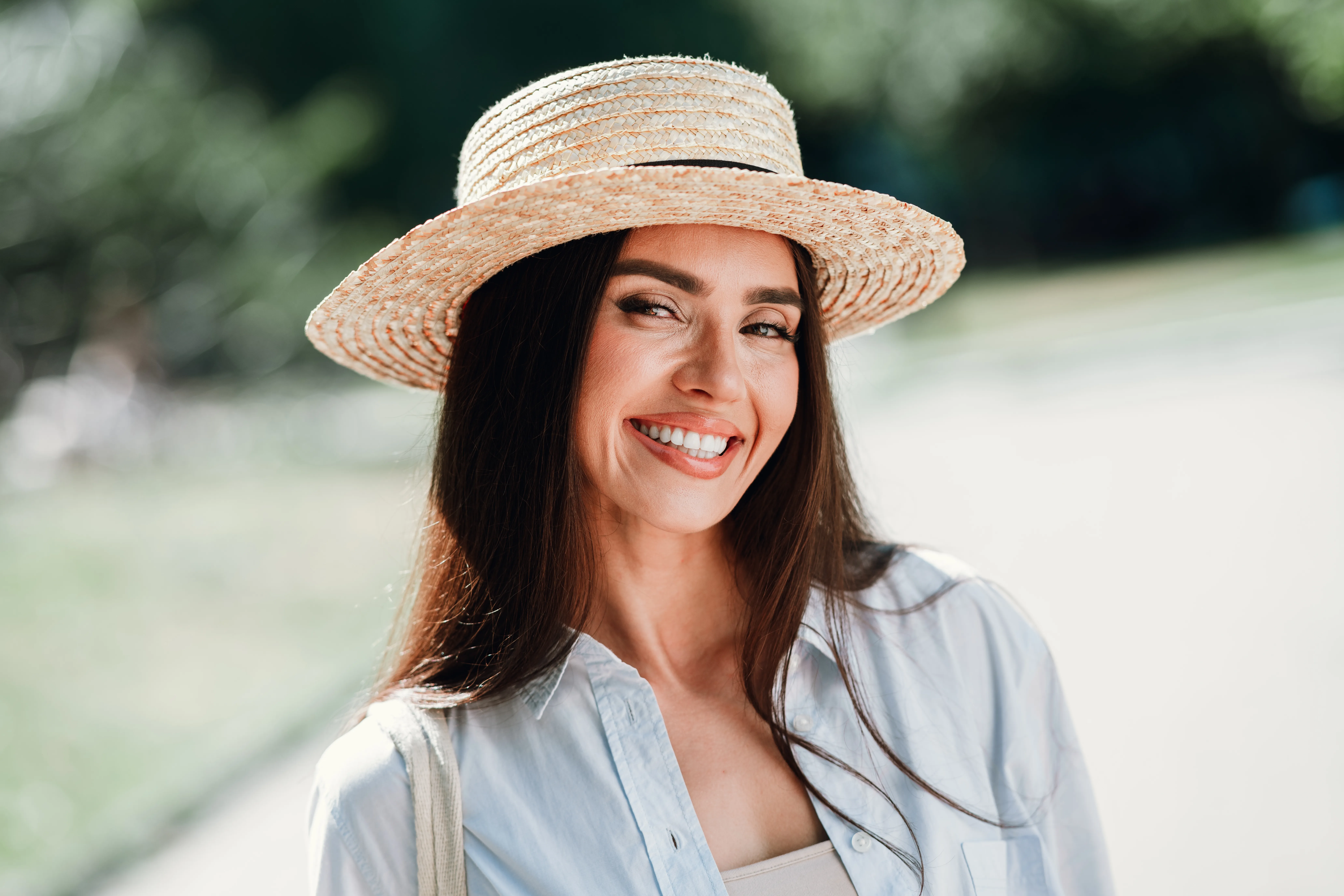 Smiling woman with healthy teeth outdoors, representing confident smile after Dental Veneers